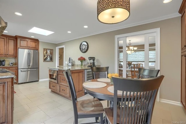 kitchen featuring crown molding, light stone countertops, a skylight, a chandelier, and high quality fridge