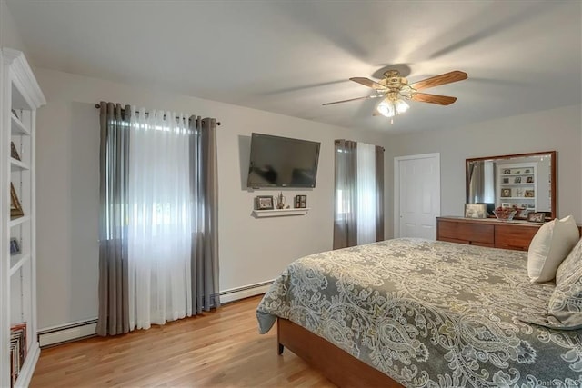 bedroom featuring light hardwood / wood-style flooring, a closet, a baseboard heating unit, and ceiling fan