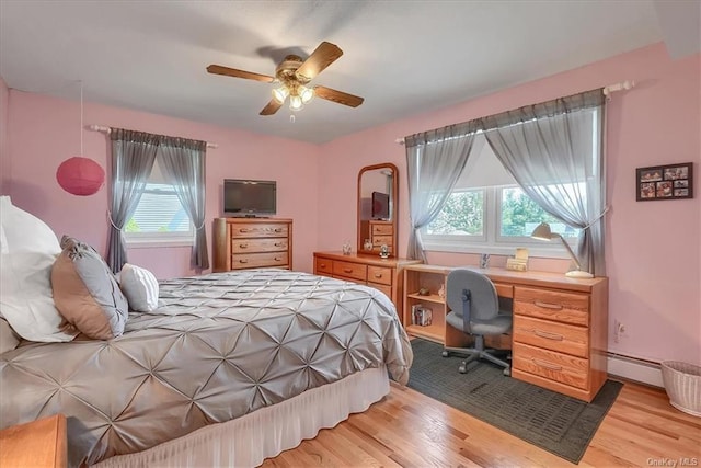 bedroom featuring ceiling fan, light hardwood / wood-style flooring, and baseboard heating