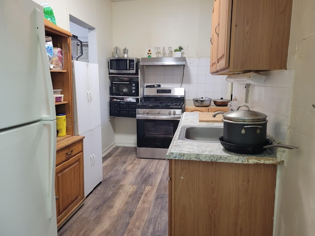 kitchen featuring sink, backsplash, appliances with stainless steel finishes, and dark hardwood / wood-style floors