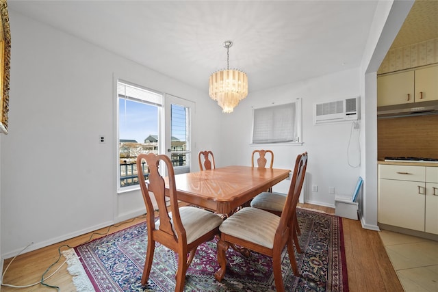 dining area featuring light hardwood / wood-style floors, a chandelier, and a wall mounted AC