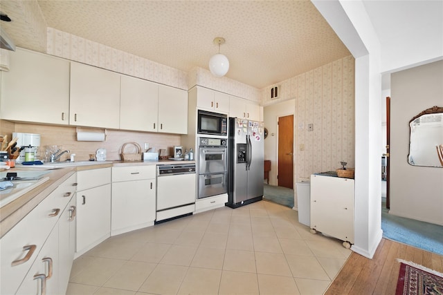 kitchen featuring sink, white cabinets, decorative backsplash, and appliances with stainless steel finishes