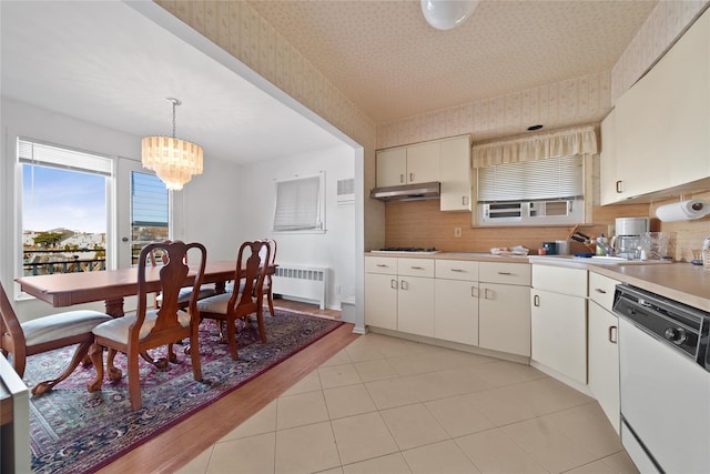 kitchen with radiator, gas stovetop, dishwasher, decorative backsplash, and decorative light fixtures