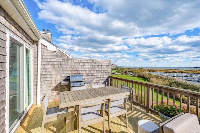 balcony with area for grilling and a deck with water view