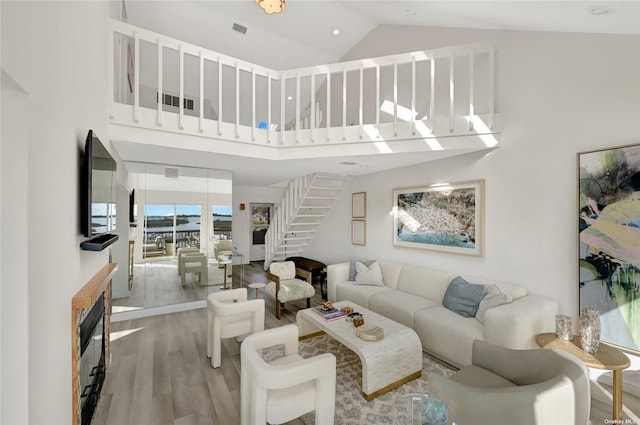 living room with hardwood / wood-style floors and a towering ceiling