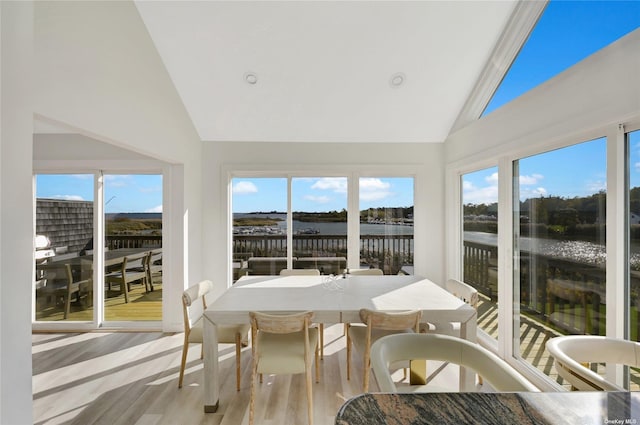 sunroom / solarium featuring lofted ceiling and a water view