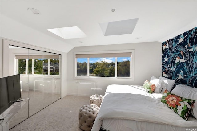 bedroom featuring a closet, lofted ceiling with skylight, and carpet floors