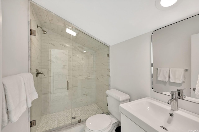 bathroom featuring vanity, toilet, and a shower with shower door