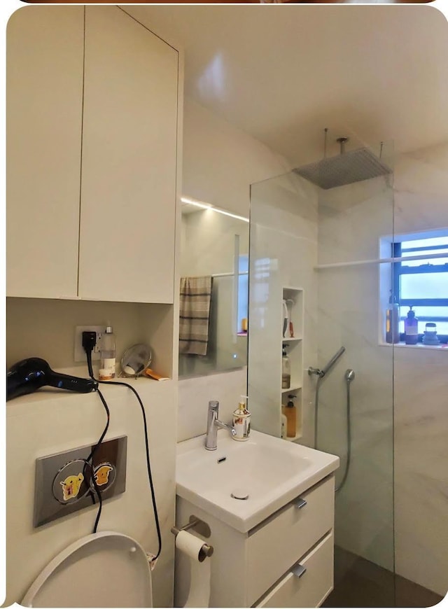 bathroom featuring vanity and tiled shower