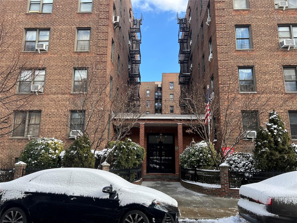 snow covered building featuring cooling unit