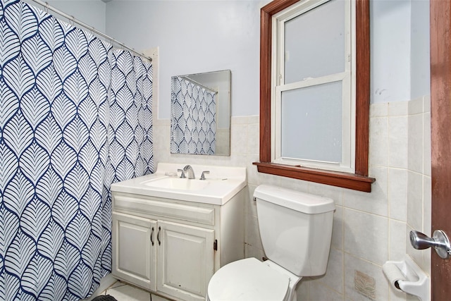 bathroom featuring vanity, tile walls, walk in shower, and toilet