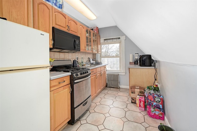 kitchen with gas stove, tasteful backsplash, vaulted ceiling, radiator heating unit, and white fridge