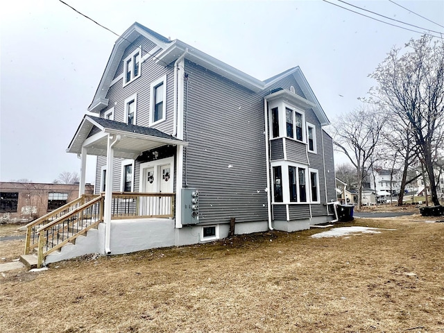 view of side of property with a porch and a yard