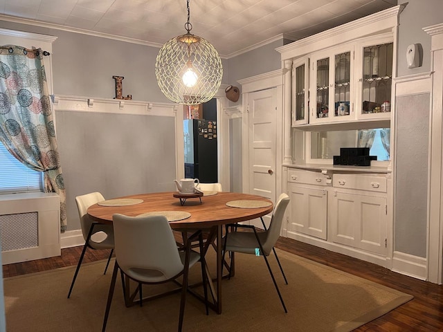 dining space featuring dark hardwood / wood-style floors and crown molding