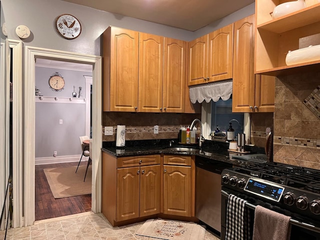 kitchen featuring decorative backsplash, dark stone counters, sink, and stainless steel appliances