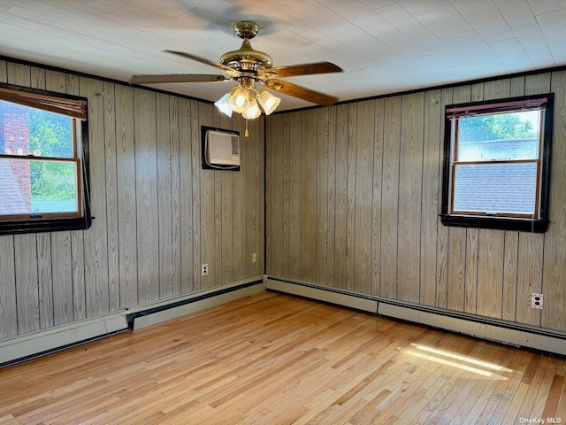 spare room featuring wood walls, ceiling fan, plenty of natural light, and light wood-type flooring