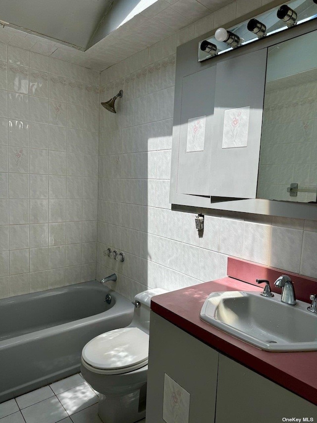 full bathroom with toilet, vanity, tile patterned floors, tiled shower / bath combo, and decorative backsplash