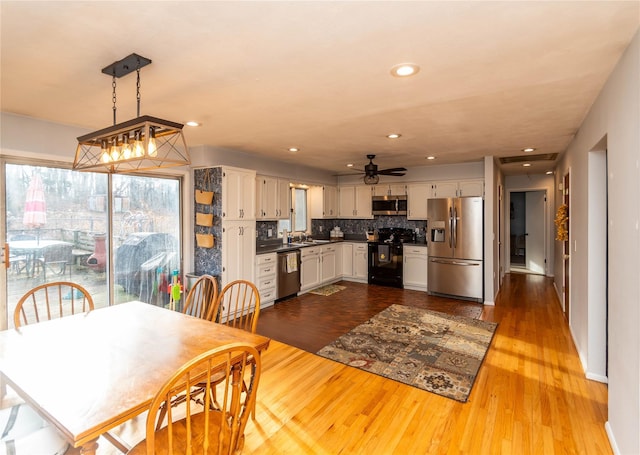 dining room with ceiling fan, wood-type flooring, and sink