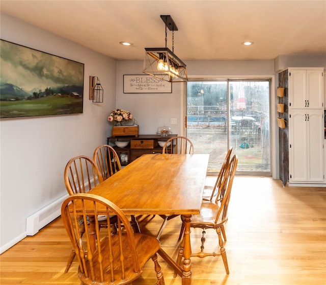 dining space with baseboard heating and light wood-type flooring