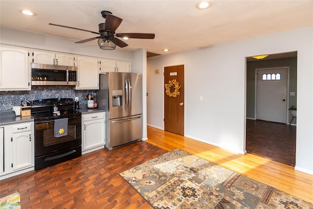 kitchen featuring ceiling fan, backsplash, white cabinetry, and stainless steel appliances