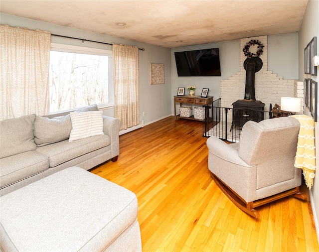 living room with a wood stove and hardwood / wood-style floors