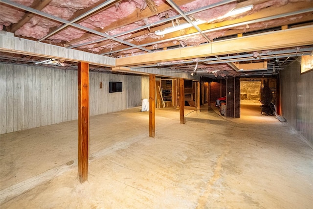 basement featuring wooden walls