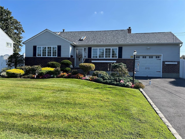 ranch-style home featuring a front lawn, aphalt driveway, an attached garage, brick siding, and a chimney