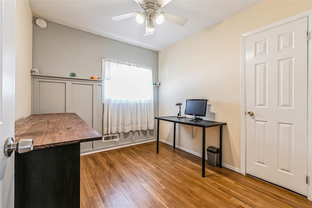 office area with visible vents, baseboards, wood finished floors, and a ceiling fan