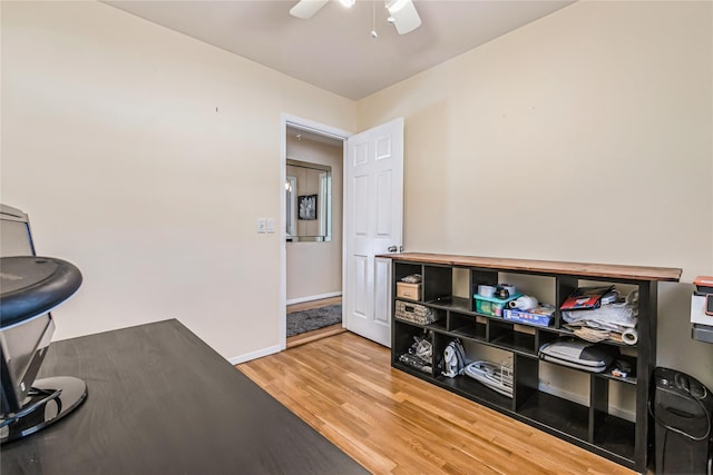 interior space featuring a ceiling fan, wood finished floors, and baseboards