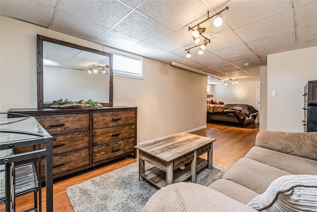 living room featuring a paneled ceiling, wood finished floors, and track lighting