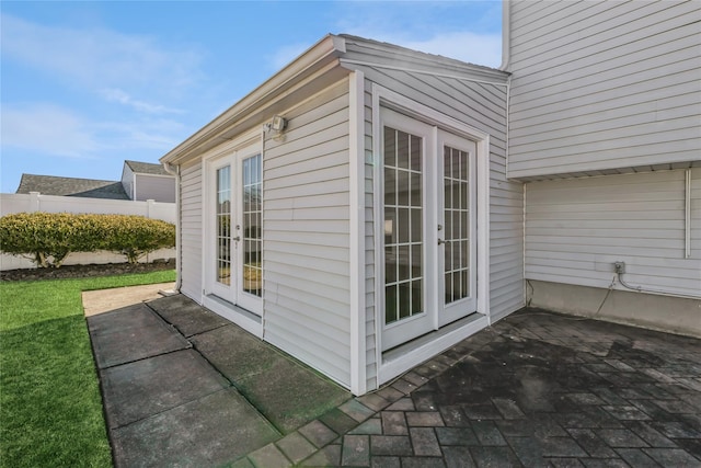 view of side of home featuring a patio, french doors, and fence