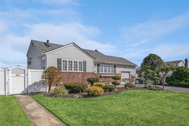 ranch-style home with a gate, fence, a front yard, a shingled roof, and brick siding