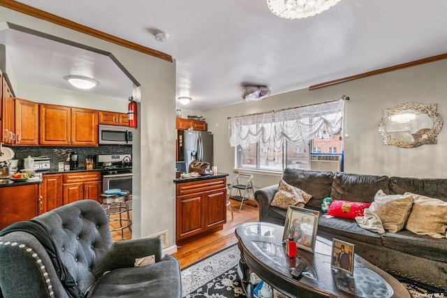 living room with crown molding and light hardwood / wood-style flooring