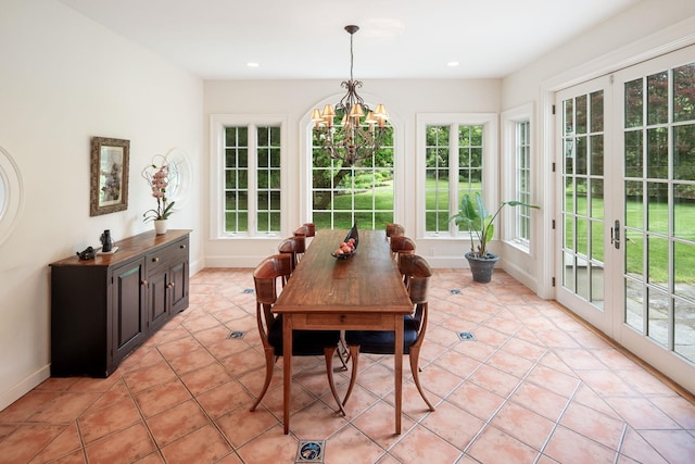 sunroom featuring french doors and a chandelier