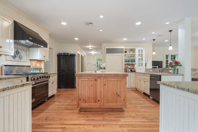 kitchen with high end range, dishwasher, extractor fan, a sink, and light wood-style floors
