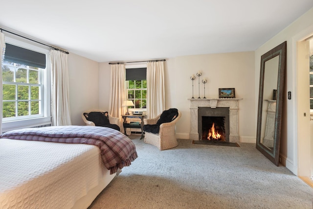 carpeted bedroom featuring a fireplace with flush hearth