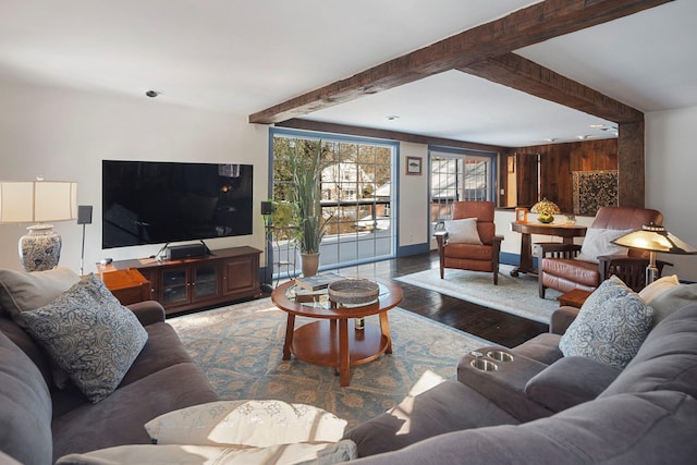 living room featuring beam ceiling, wood walls, and hardwood / wood-style flooring