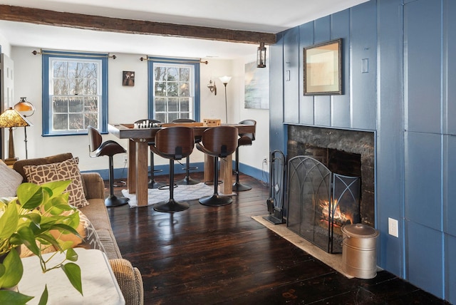 interior space with dark wood-type flooring and beam ceiling