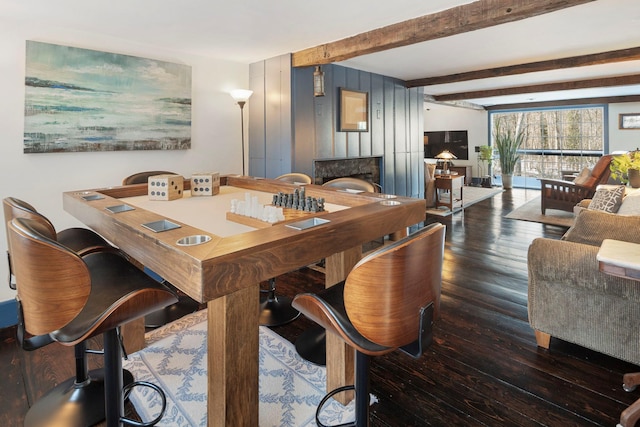 dining area with dark wood-type flooring and beamed ceiling