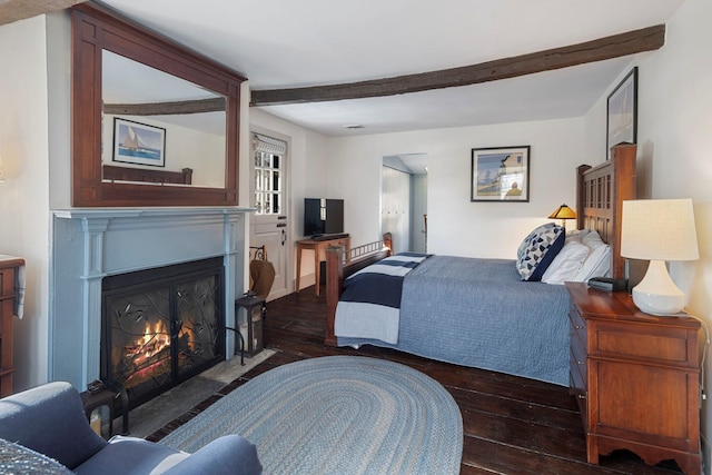 bedroom featuring dark hardwood / wood-style floors and beam ceiling