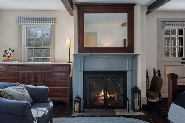 living area with beam ceiling and dark wood-type flooring