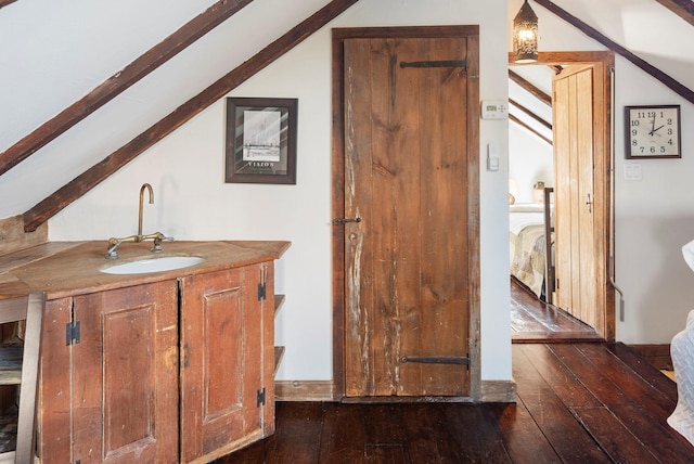 bathroom featuring lofted ceiling, vanity, and hardwood / wood-style floors