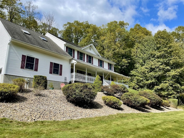 exterior space featuring covered porch and a lawn