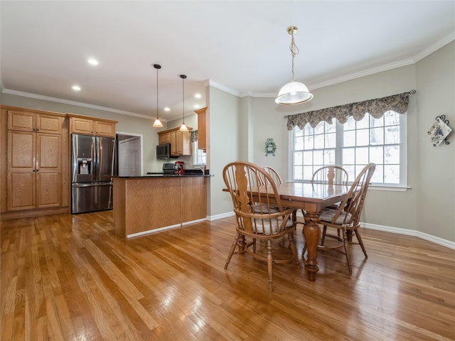 dining room featuring crown molding and light hardwood / wood-style flooring