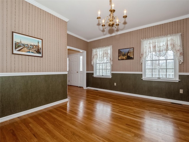 unfurnished dining area with crown molding, hardwood / wood-style floors, and a chandelier