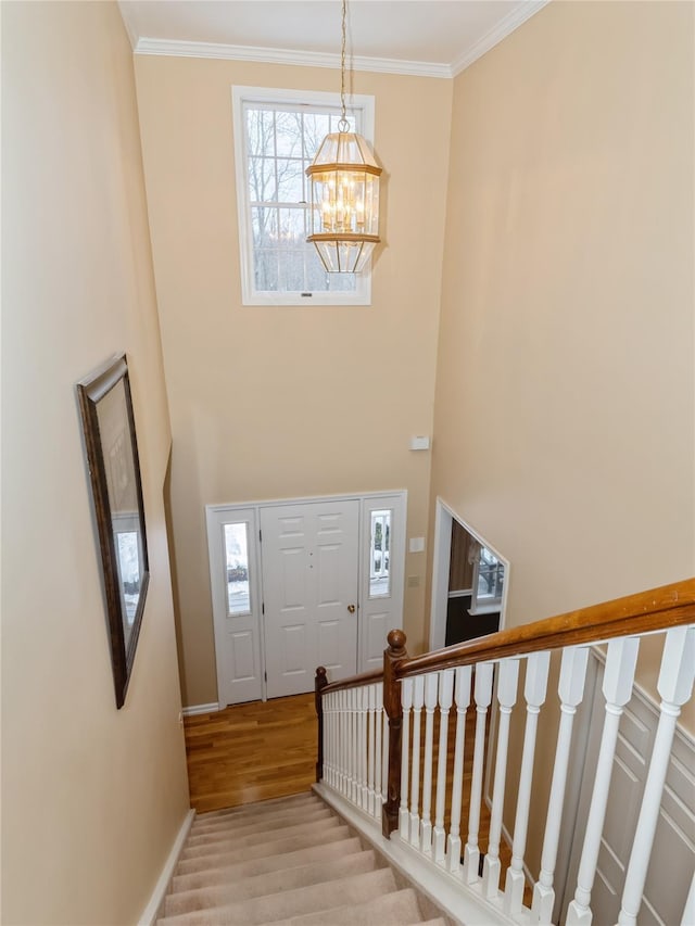 entryway with ornamental molding, a chandelier, and light hardwood / wood-style floors