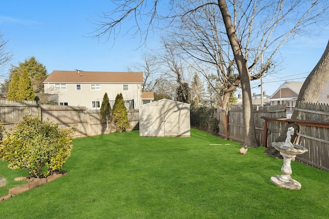 view of yard with an outbuilding, a fenced backyard, and a storage unit