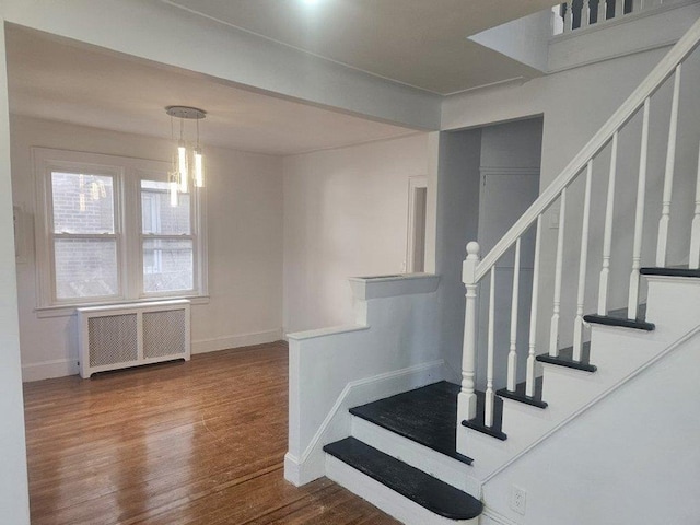 stairs with radiator heating unit and hardwood / wood-style floors