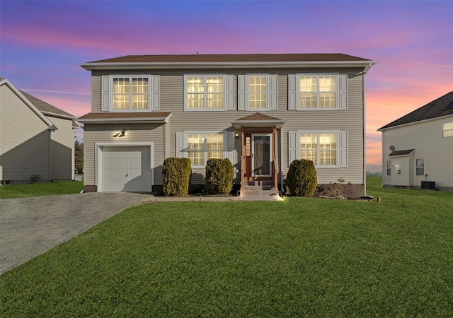 view of front of home with a garage and a yard