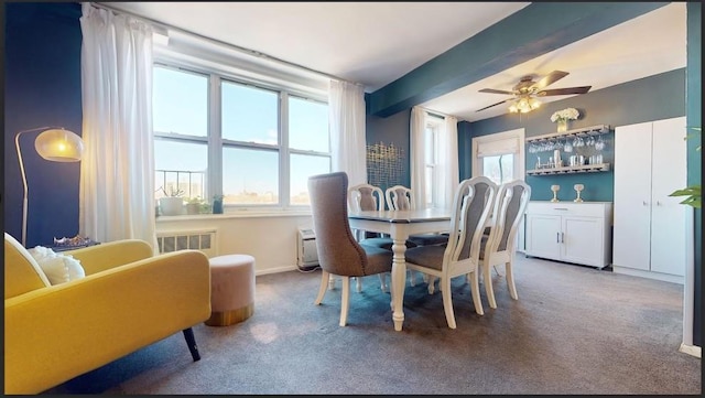 dining room with ceiling fan, radiator, beamed ceiling, and carpet flooring